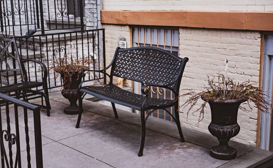 Stalen plantenbak op poten in een moderne tuin met mooie beplanting.